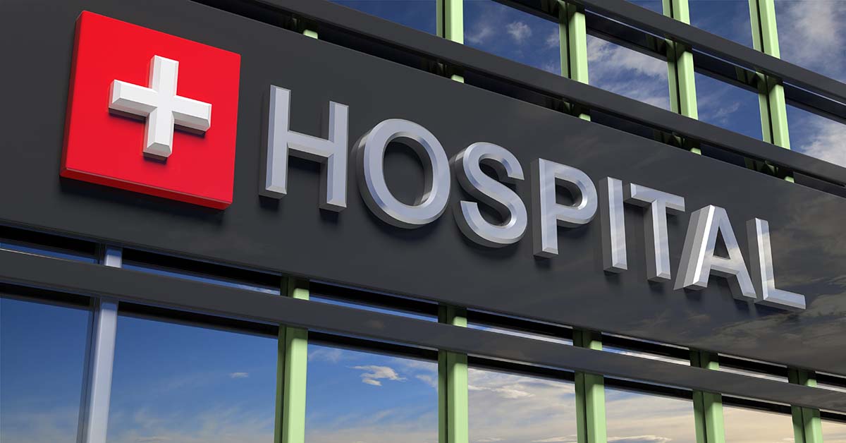 Hospital,Building,Sign,Closeup,,With,Sky,Reflecting,In,The,Glass